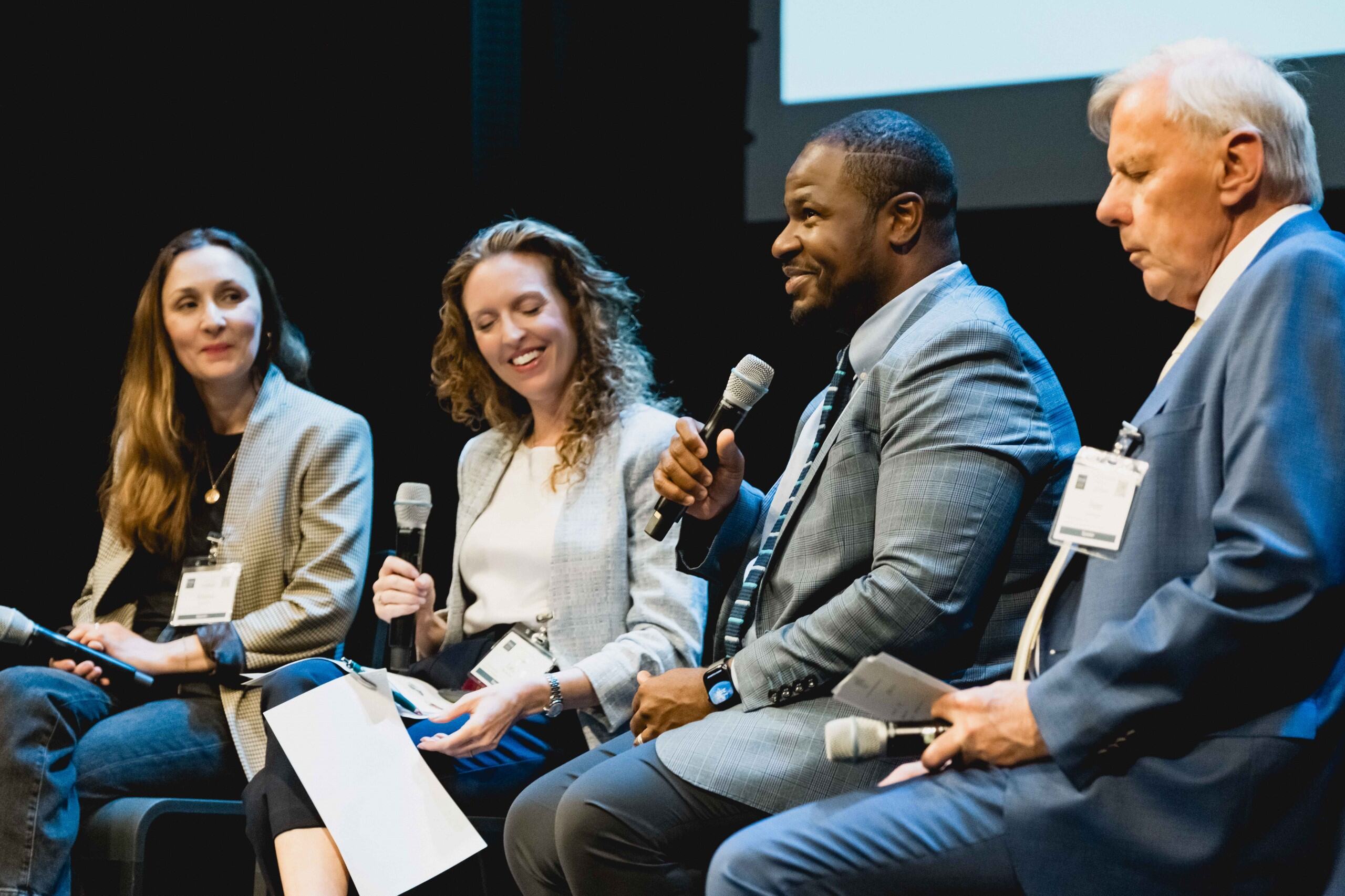A panel of four people speaking on stage