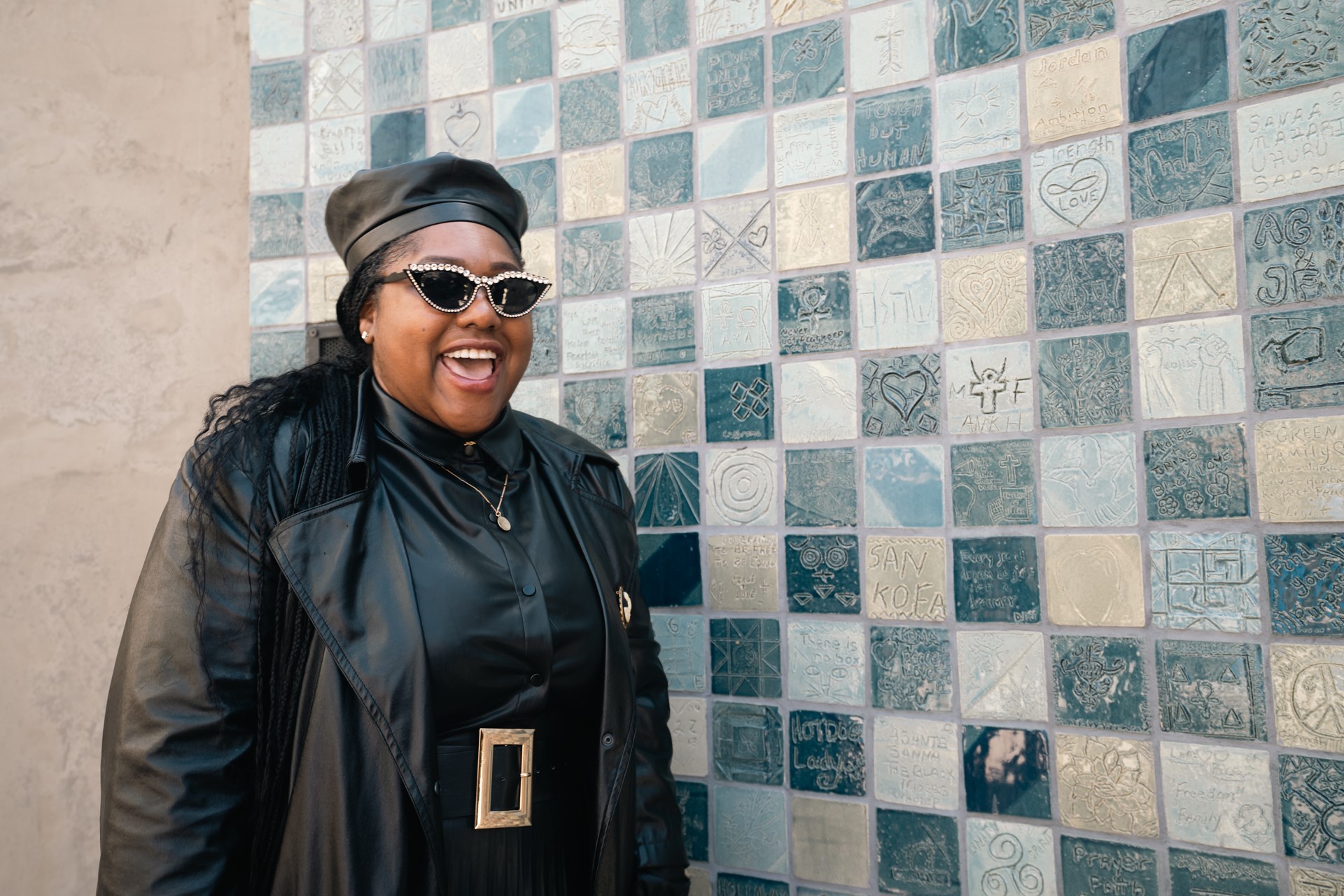 Local Artist Tiffany Salas poses with the mosaic wall